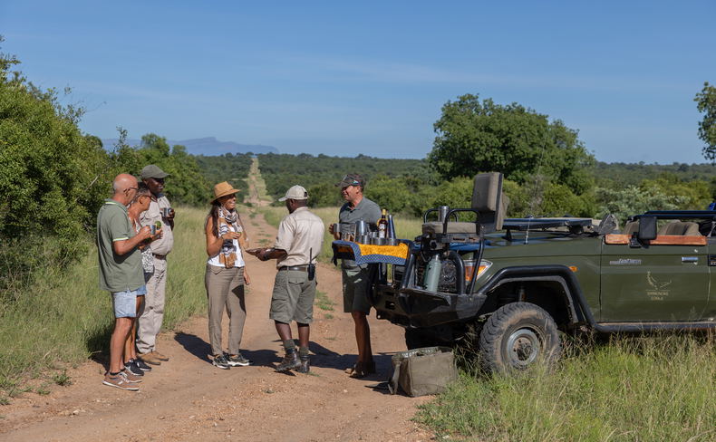 Guests on open air vehicles enjoying a guided big five African safari Guests on open air vehicles enjoying a guided big five African safari