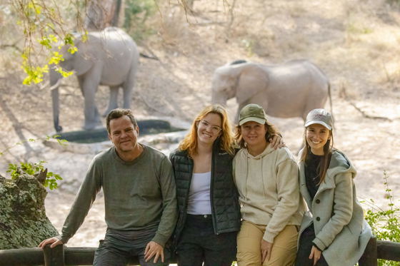 Family African safari watching elephants at a waterhole in front of Shimungwe Lodge, Thornybush Game Reserve, Greater Kruger Family African safari watching elephants at a waterhole in front of Shimungwe Lodge, Thornybush Game Reserve, Greater Kruger