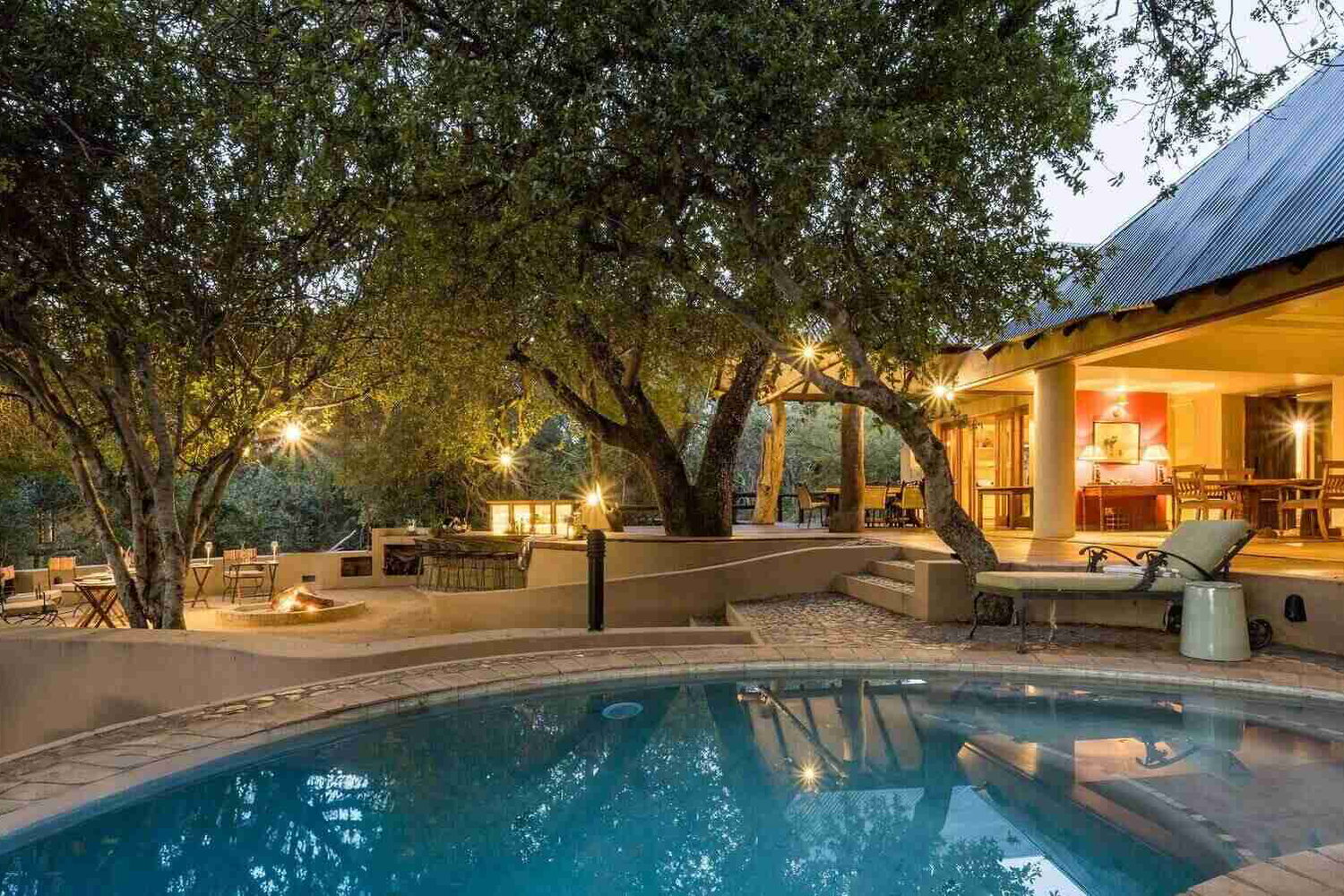 Shimungwe Lodge open outdoor living flows from the main unit out on to the patio and swimming pool and open boma overlooking the river bed in Greater Kruger