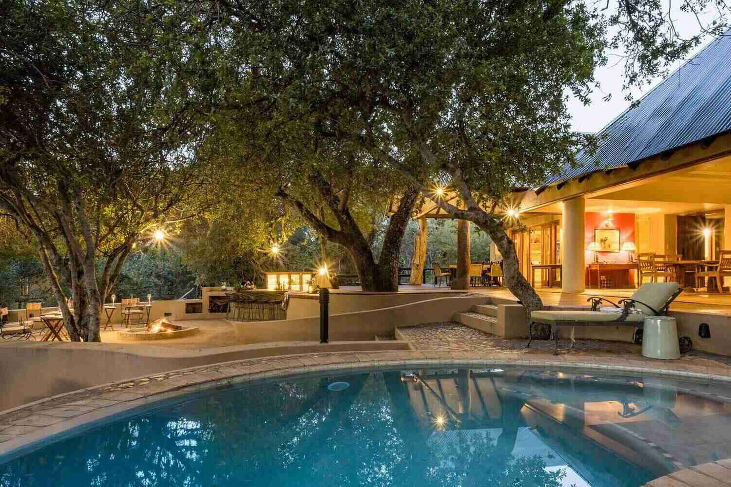 Shimungwe Lodge open outdoor living flows from the main unit out on to the patio and swimming pool and open boma overlooking the river bed in Greater Kruger