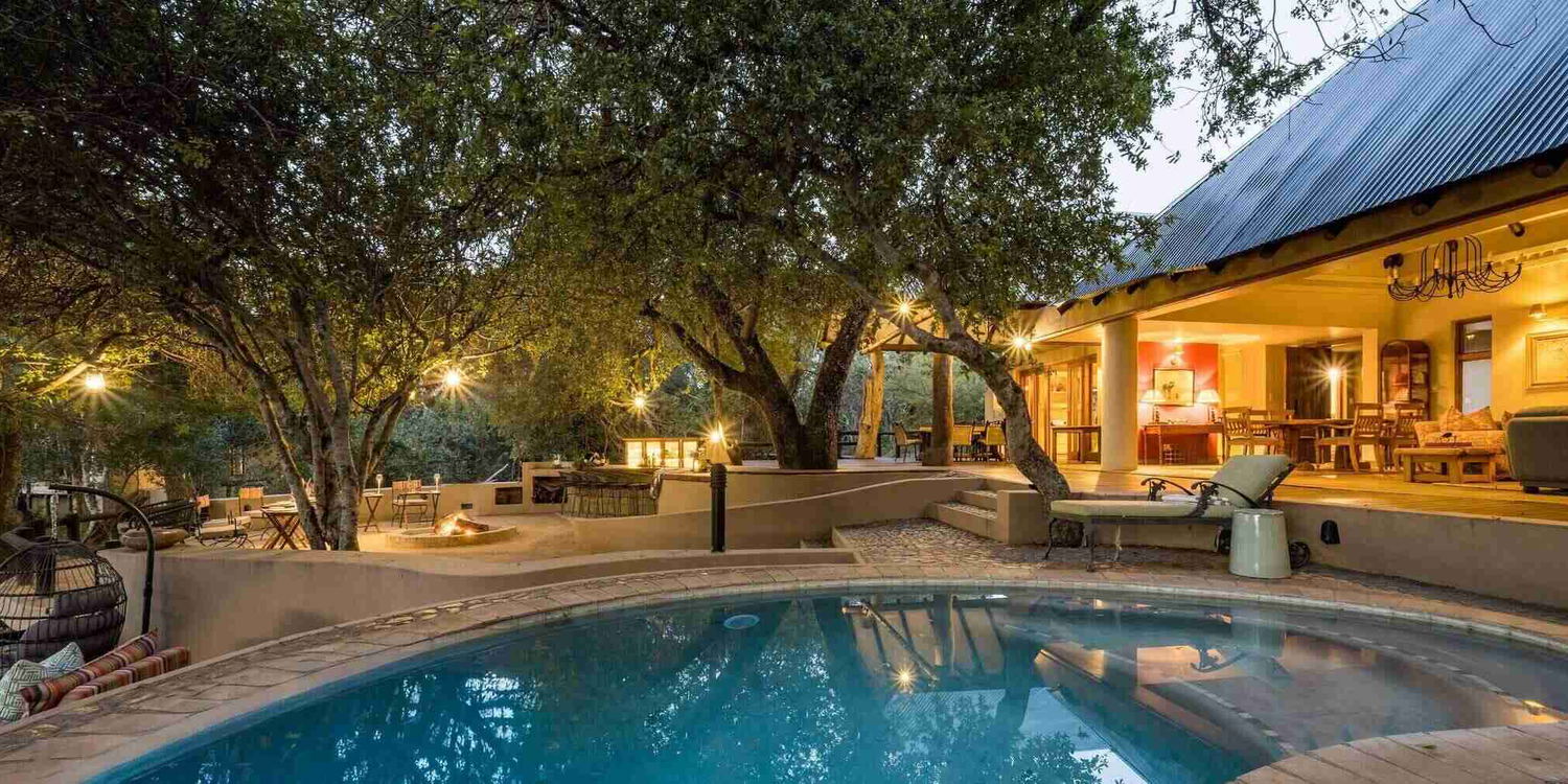 Shimungwe Lodge open outdoor living flows from the main unit out to the patio and swimming pool and open boma overlooking the river bed in Greater Kruger