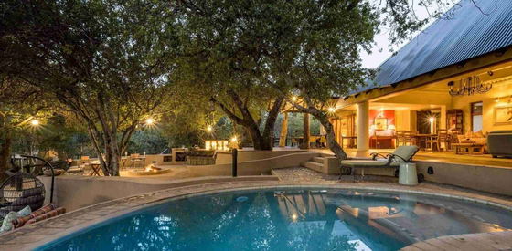 Shimungwe Lodge open outdoor living flows from the main unit out to the patio and swimming pool and open boma overlooking the river bed in Greater Kruger Shimungwe Lodge open outdoor living flows from the main unit out to the patio and swimming pool and open boma overlooking the river bed in Greater Kruger