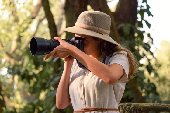 Wildlife photographer focusing her camera on wildlife, Thornybush Game Reserve, South Africa Wildlife photographer focusing her camera on wildlife, Thornybush Game Reserve, South Africa