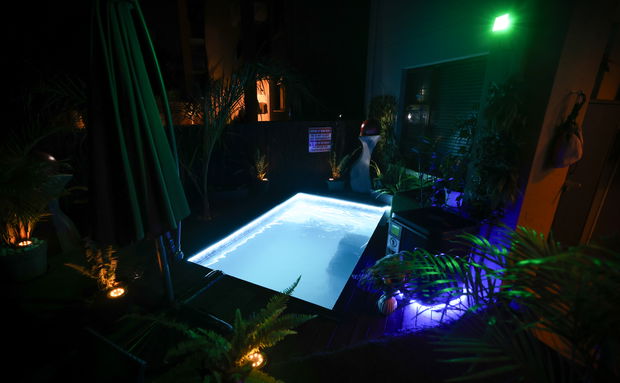 Luxury heated splash pool illuminated at night in a private garden at Sunrise Apartment, premium accommodation near O.R. Tambo International Airport in Benoni.