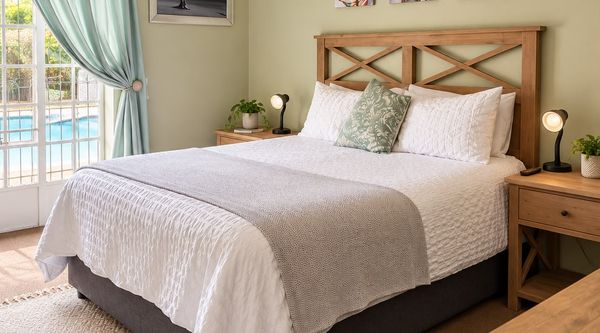Main bedroom in the Protea Family Suite at Amberlight Guesthouse in Krugersdorp, with a view towards the shared pool.