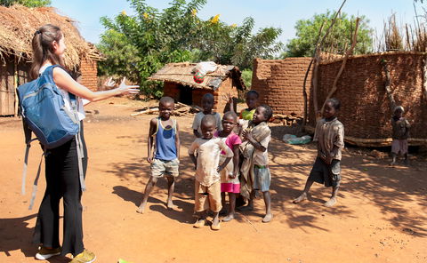 girl from ireland playing with a ball with children in a village in malawi