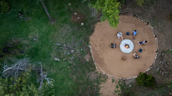 Ngoma Bush Lodge boma with seating arranged around a central fire pit, ambient lantern lighting, and a natural bushveld backdrop