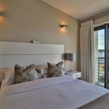Relax in a bright, airy bedroom with crisp white linens, Enjoy luxury and natural light at Hermanus Luxury Accommodation by DCC Hotel Group