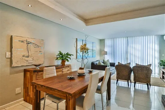 Enjoy a cozy dining experience in a room designed with a stylish table and chairs. The tasteful flooring and elegant interior design creates a relaxing atmosphere typical of a boutique hotel suite at Hermanus Luxury Accommodation by the DCC Hotel Group