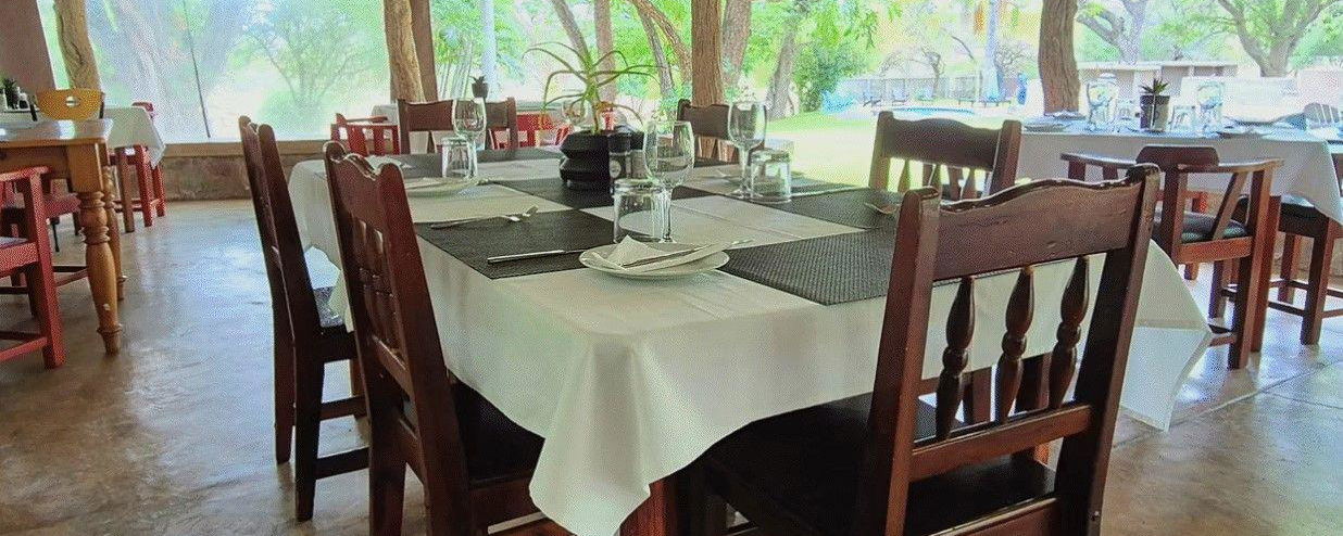 Open thatched dining area where guests enjoy breakfasts, dinners and relaxed home-style meals.