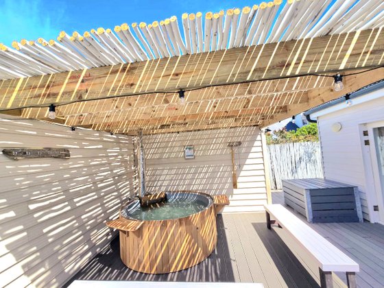 Hot tub area with fairy lights, firewood and drink trays