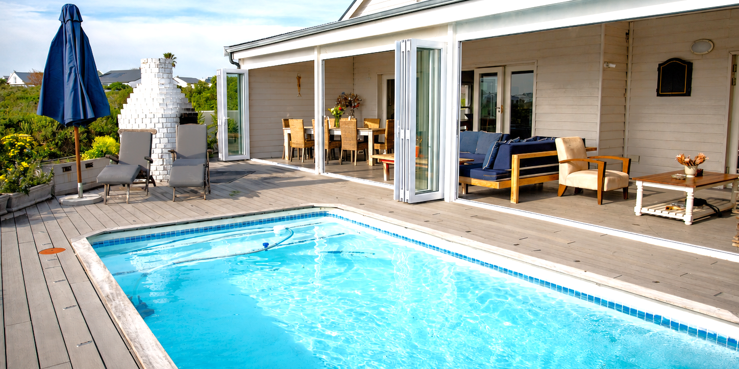 Veranda with lounges, dining table and pool view