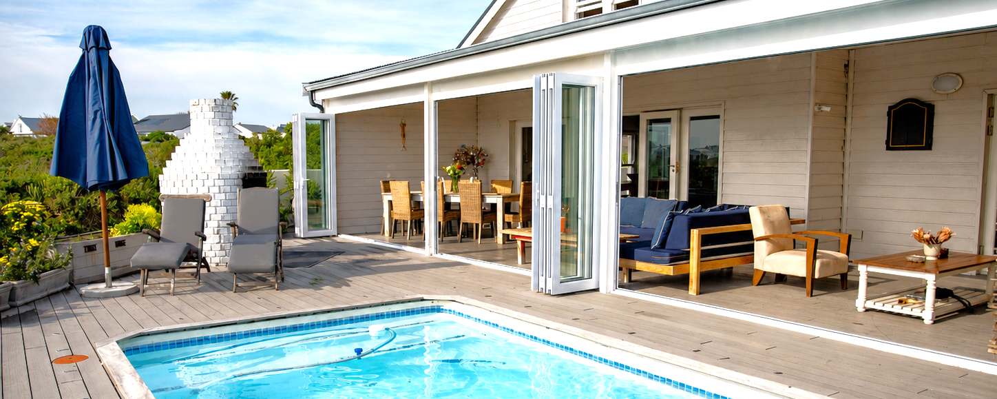 Veranda with lounges, dining table and pool view