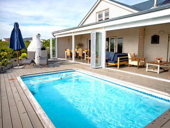 Veranda with lounges, dining table and pool view