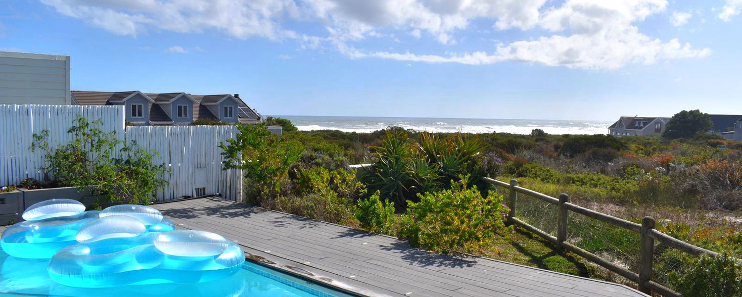 View from the pool deck over the pool, fynbos and sea