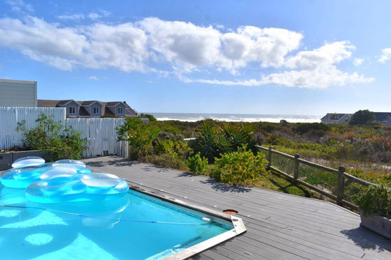 View from the pool deck over the pool, fynbos and sea