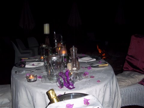 Romantic table setting on deck next to fire