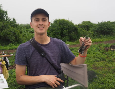 A 2023 photo of Ezra holding a Diederik Cuckoo with the habitat in the background ...