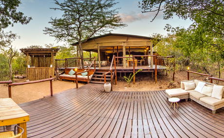 view of the main lodge area at Ngama Tented Safari Lodge with indoor and outdoor seating view of the main lodge area at Ngama Tented Safari Lodge with indoor and outdoor seating