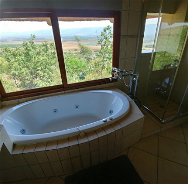 Red Sky Lodge - Upper west spa bath and shower with a view over the Hartbeespoort valley