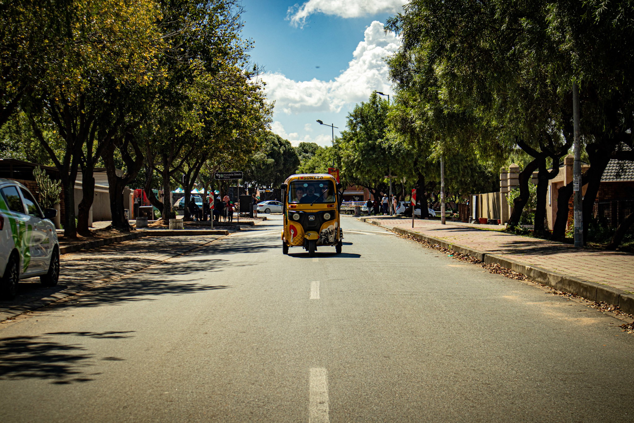 Visitors exploring Soweto on a guided tuk tuk tour with Lebo's history and culture.