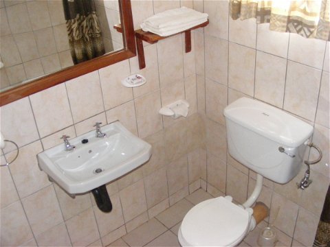 Double room toilet and handbasin with mirror and toiletries shelf
