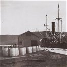 ss Outeniqua offloads petrol barrels which will be transported by donkey wagon to Willowmore. Early 20th Century