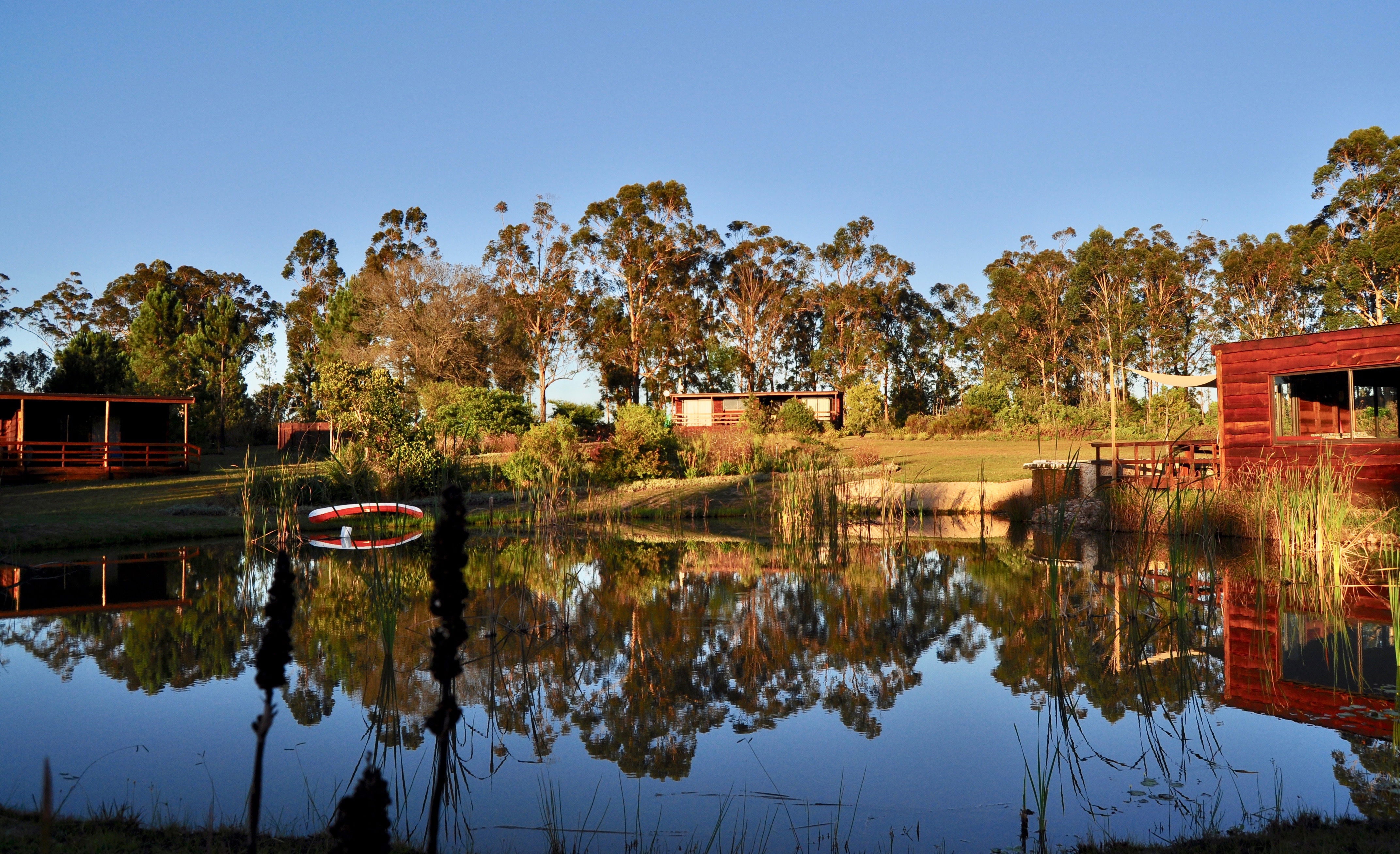 Venue building and cottages across dam near Plettenberg Bay