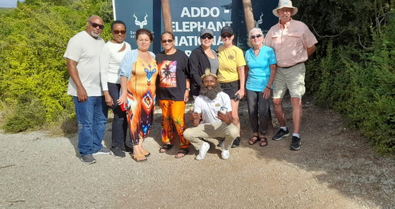 Our Into Tours guide proudly photographed with a bread and traditional xhosa head band,  by the Addo Elephant National Park sign, ready to lead guests on an amazing safari game drive. With expert knowledge and a friendly approach, the tour is fun, educational, and full of captivating wildlife moments, creating unforgettable safari and wildlife memories for every guest.