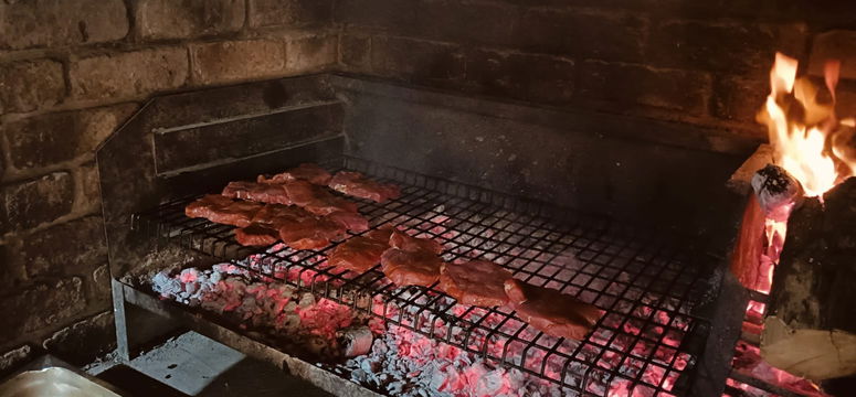 Enjoy a traditional South African braai with perfectly grilled meat, a must-have experience on your Addo adventure.