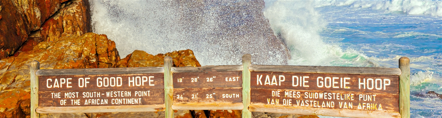 Picture of the Cape of Good Hope in Cape Peninsula with rocks and water splashing over signboards.