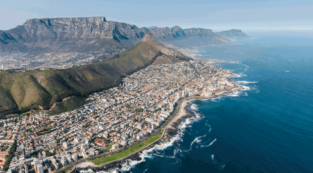 Cape Town Peninsula Tour: Aerial View of Table Mountain and Cape Peninsula.This stunning perspective captures Table Mountain’s iconic flat-topped summit and the sweeping curves of the Cape Peninsula, where dramatic cliffs plunge into the Atlantic Ocean.this aerial view highlights Cape Town’s natural beauty and rugged coastal landscapes.