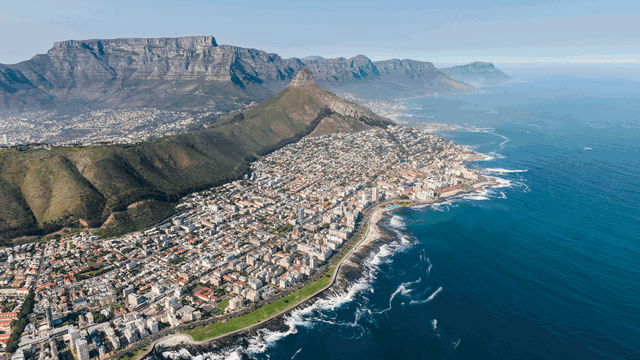 Cape Town Peninsula Tour: Aerial View of Table Mountain and Cape Peninsula.This stunning perspective captures Table Mountain’s iconic flat-topped summit and the sweeping curves of the Cape Peninsula, where dramatic cliffs plunge into the Atlantic Ocean.this aerial view highlights Cape Town’s natural beauty and rugged coastal landscapes.