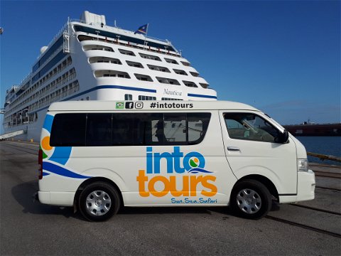 Tour vehicle parked near a cruise ship that arrived to Port Elizabeth Harbour to take cruise ship passengers on a shore excursion in Port Elizabeth to the Addo Elephant National Park with Into Tours a shore excursion tour operator  