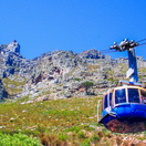 Photograph of tourists in the Table Mountain cable car, in Cape Town, South Africa. The picture has Table Mountain as a back drop