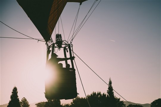 People on a hot-air Balloon as the sun is rising over the Cape Winelands