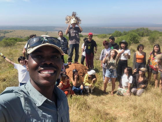 Tour guide explaining the habits of animals and unique vegetation to smiling visitors.