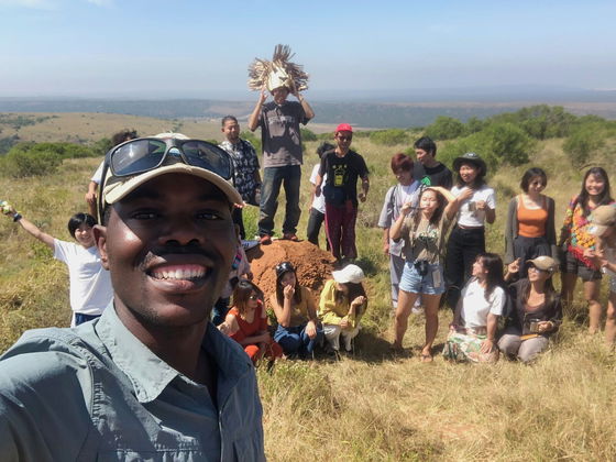 Tour guide explaining the habits of animals and unique vegetation to smiling visitors.