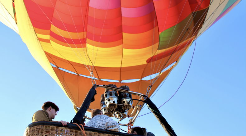People that are in the basket of a Hot-Air-Balloon that is lifting off the ground in the Cape Winelands South Africa People that are in the basket of a Hot-Air-Balloon that is lifting off the ground in the Cape Winelands South Africa