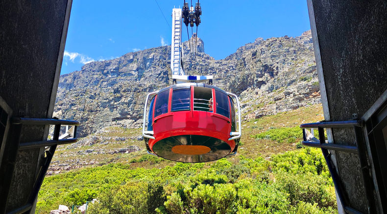 Table mountain in Cape Town, riding the table mountain cable car that summits to the top of Table Mountain as seen on a guided Cape Town tour with Into Tours, tour operator in Cape Town Table mountain in Cape Town, riding the table mountain cable car that summits to the top of Table Mountain as seen on a guided Cape Town tour with Into Tours, tour operator in Cape Town