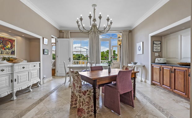 Elegant breakfast room at Devonport House in Constantia, featuring a light-filled dining space with a wooden table, upholstered chairs, chandelier, marble floors, and views of the garden — perfect for relaxed morning meals in Cape Town. Elegant breakfast room at Devonport House in Constantia, featuring a light-filled dining space with a wooden table, upholstered chairs, chandelier, marble floors, and views of the garden — perfect for relaxed morning meals in Cape Town.