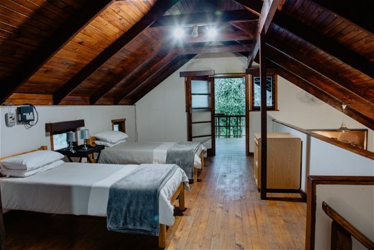 Two single beds in the spacious loft area leading off to the top story deck at The Wooden Forest House