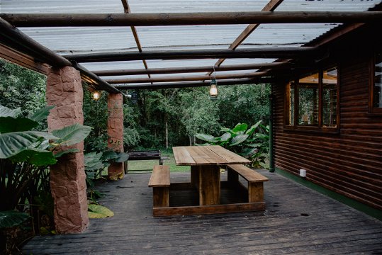 Large private wooden deck with table, bench set and braai at The Wooden Forest House