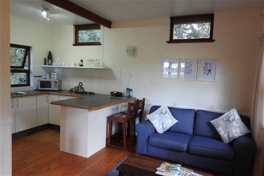 Main living area with sofa and fully equipped kitchen at Natures Way Farm Cottage