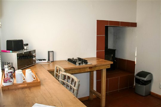 Fully equipped self-catering kitchen with gas kettle, stovetop, toaster, microwave, bar fridge at The Bush Pig Cottage