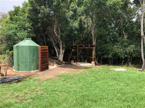 Grassy campground at Exclusive Campsite 2 with braai area, covered area, private shower and toilet unit 