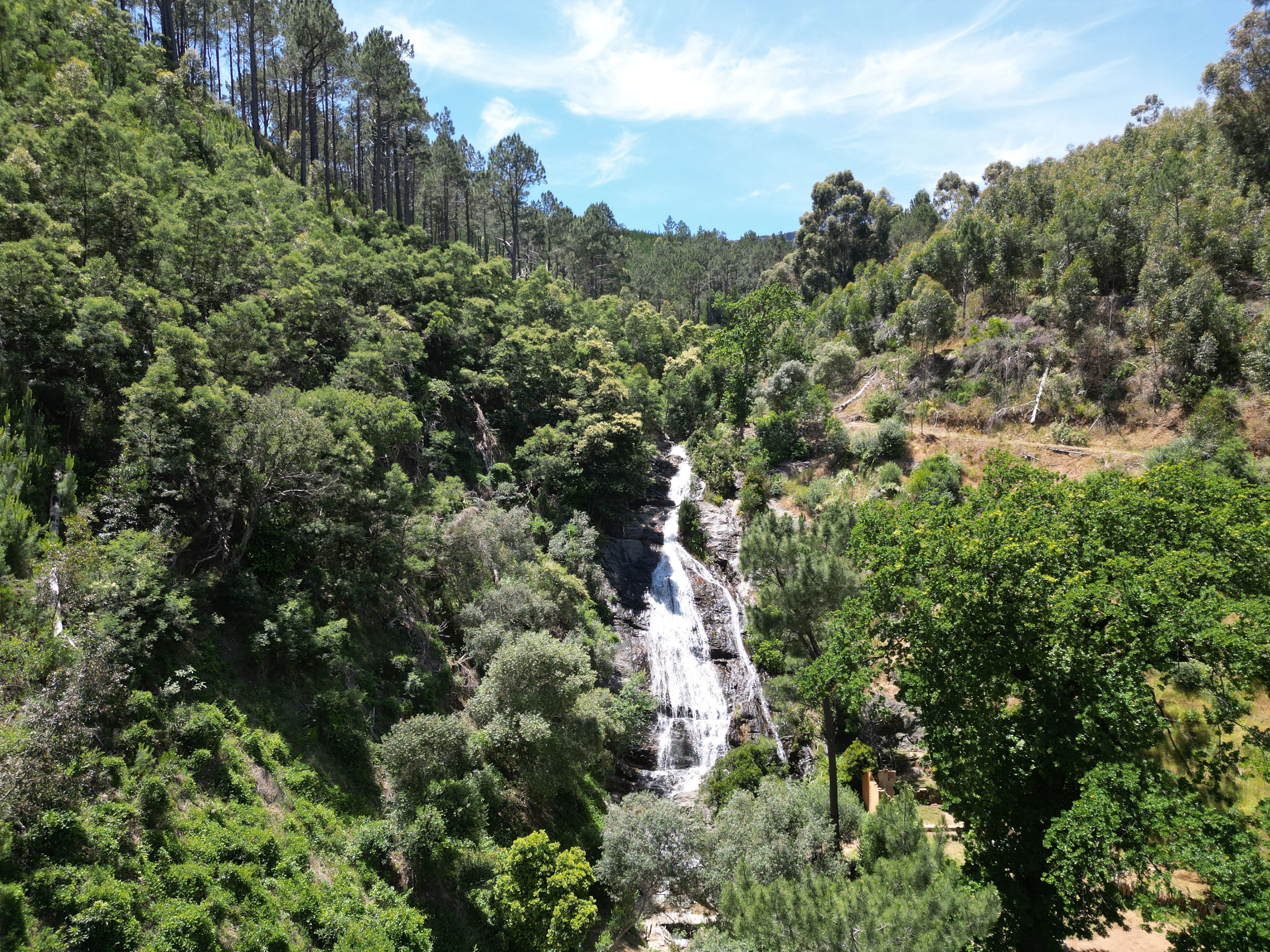 a stream cascading down the granite rock face forming the waterfall 