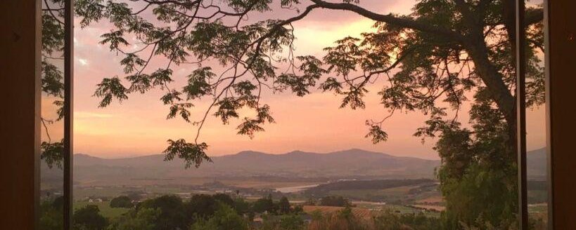 A sunset view over farmlands towards Stellenbosch hills and Table Mountain