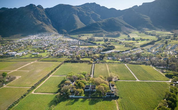 Aerial view of farmland and vineyards with a small town and mountains in the background Aerial view of farmland and vineyards with a small town and mountains in the background