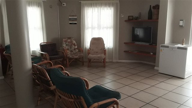 The spacious lounge at Tolbos. Comfortable chairs, with a refrigerator in the corder, and a television. 